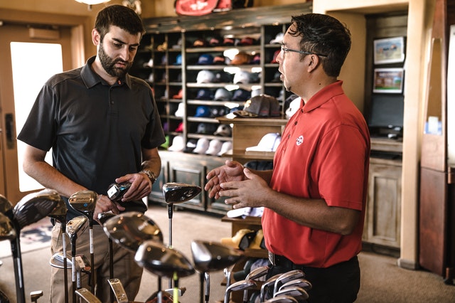 two men talking about golf clubs
